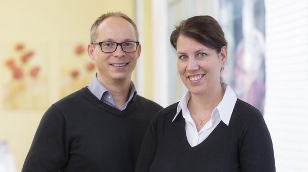 Zwei freundliche Mitarbeitende in moderner Praxis für Zahnarzt und Zahnärztin.